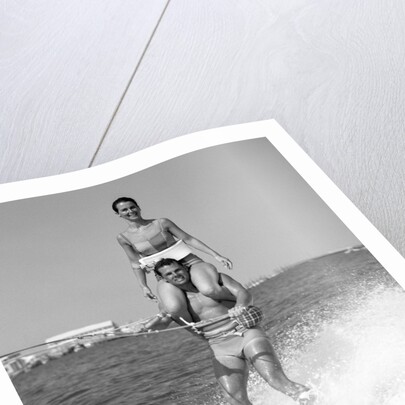 1960s Man Water Skiing With Woman In Bathing Suit Riding On Shoulders by Anonymous