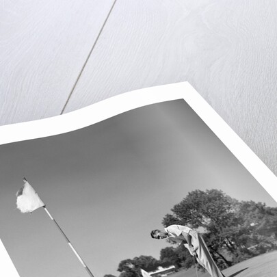 1950s Man Playing Golf Putting Golf Ball On Green To Flag And Cup Outdoor by Anonymous