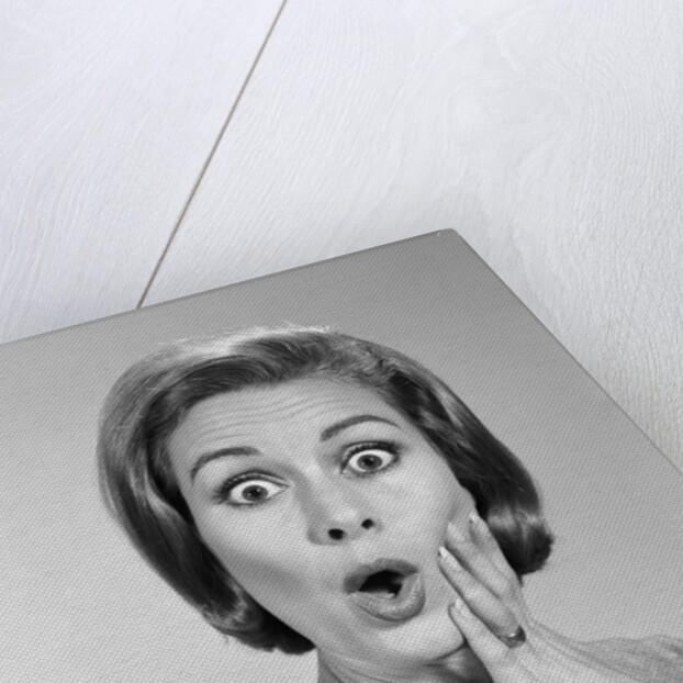 1960s Portrait Woman With Hand On Cheek Looking At Camera With Shocked Expression by Anonymous