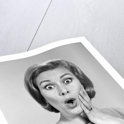 1960s Portrait Woman With Hand On Cheek Looking At Camera With Shocked Expression by Anonymous