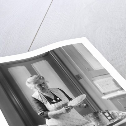 1920s 1930s Senior Woman Grandmother Wearing Apron Crimping Crust Making A Cherry Pie In Kitchen by Anonymous