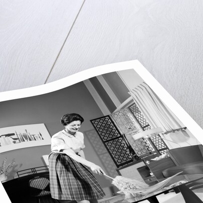 1950s 1960s Woman Wearing A White Blouse & Plaid Skirt Dusting With A Feather Duster A Glass Top Coffee Table by Anonymous