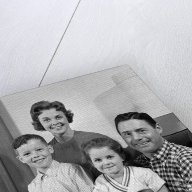 1960s Family Sitting On Couch Smiling Looking At Camera by Anonymous