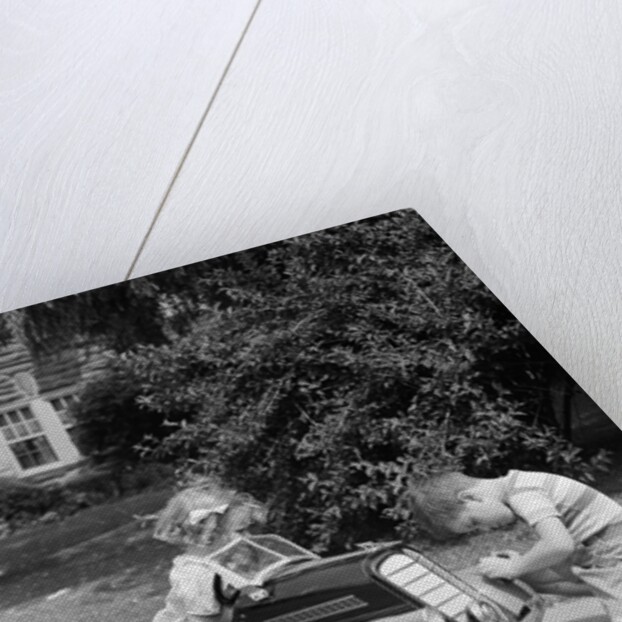 1940s 1930s Boy On Sidewalk Fixing Headlight Of Toy Car Driven By Little Girl Playing Outdoor by Anonymous