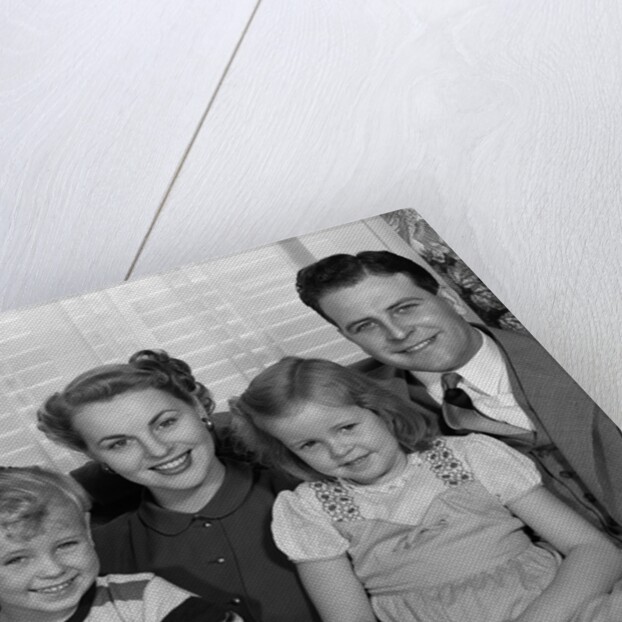 1940s 1950s Portrait Of Smiling Family Man Woman Boy Girl Sitting On Sofa Looking At Camera by Anonymous