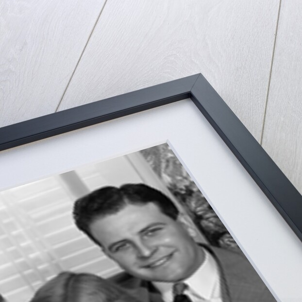 1940s 1950s Portrait Of Smiling Family Man Woman Boy Girl Sitting On Sofa Looking At Camera by Anonymous