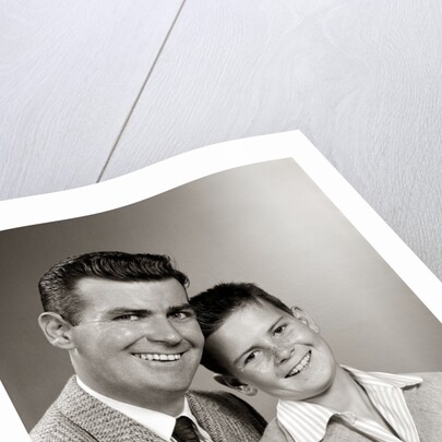 1950s Studio Portrait Smiling Man Father And Boy Son Sitting Together Looking At Camera by Anonymous