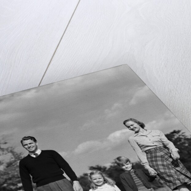 1940s Family Father Mother Son Daughter Holding Hands Together Walking On Grass by Anonymous