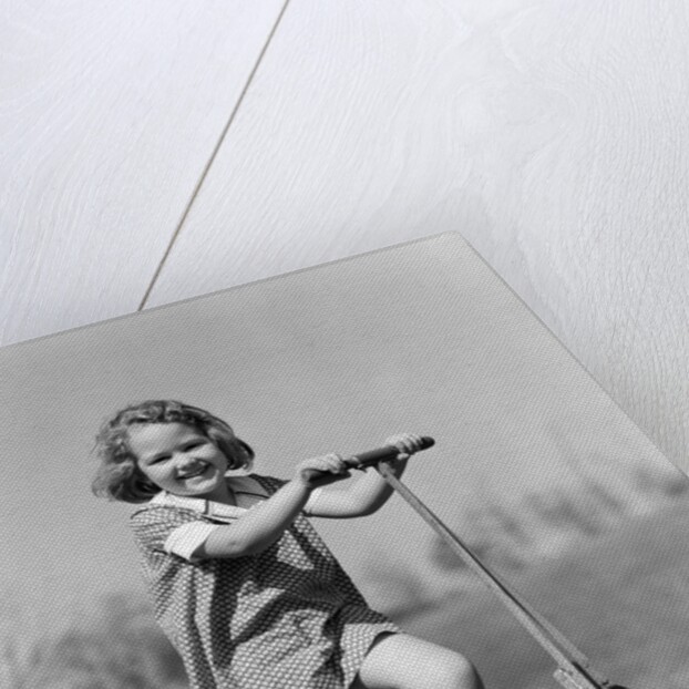 1930s Smiling Girl Playing On Scooter On Sidewalk Looking At Camera by Anonymous