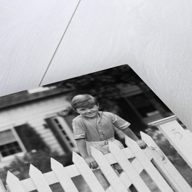1940s Child Boy Standing Swinging On White Picket Fence Gate Smiling Looking At Camera by Anonymous