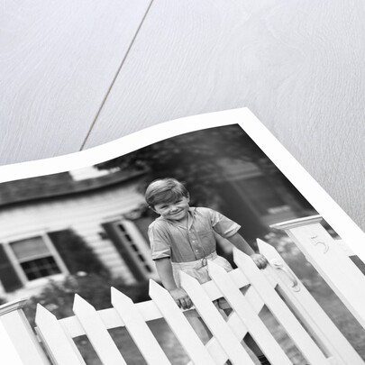 1940s Child Boy Standing Swinging On White Picket Fence Gate Smiling Looking At Camera by Anonymous