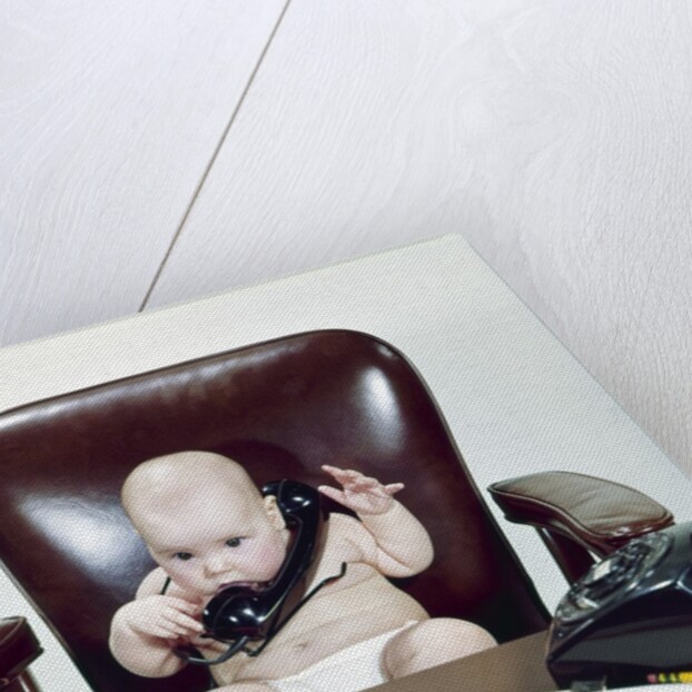 1960s Chubby Baby Sitting In Leather Office Chair Behind Desk Holding Talking On Telephone by Anonymous