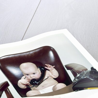 1960s Chubby Baby Sitting In Leather Office Chair Behind Desk Holding Talking On Telephone by Anonymous