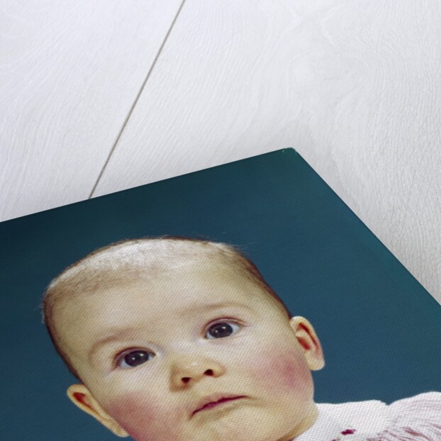 1960s Portrait Baby Girl Silly Facial Expression Red Bow At Collar Looking At Camera by Anonymous