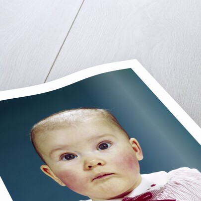 1960s Portrait Baby Girl Silly Facial Expression Red Bow At Collar Looking At Camera by Anonymous