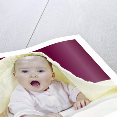 1960s Baby Mouth Wide Open Peeking Out From Under Yellow Blanket Looking At Camera by Anonymous