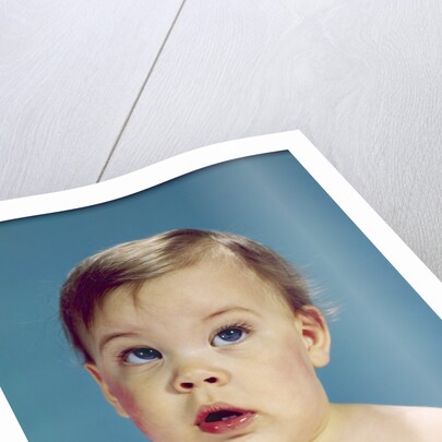 1960s Baby With Uncertain Facial Expression Deep Blue Eyes Looking Guilty Up And To The Side by Anonymous