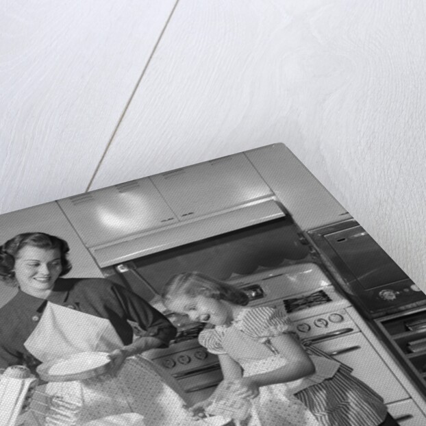 1950s mother and daughter baking a cake by Anonymous