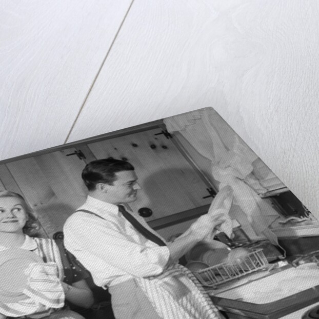 1950s smiling couple washing the dishes together by Anonymous