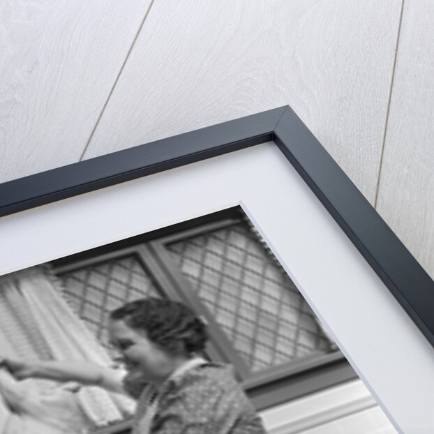 1940s housewife in kitchen showing plucked turkey to children by Anonymous