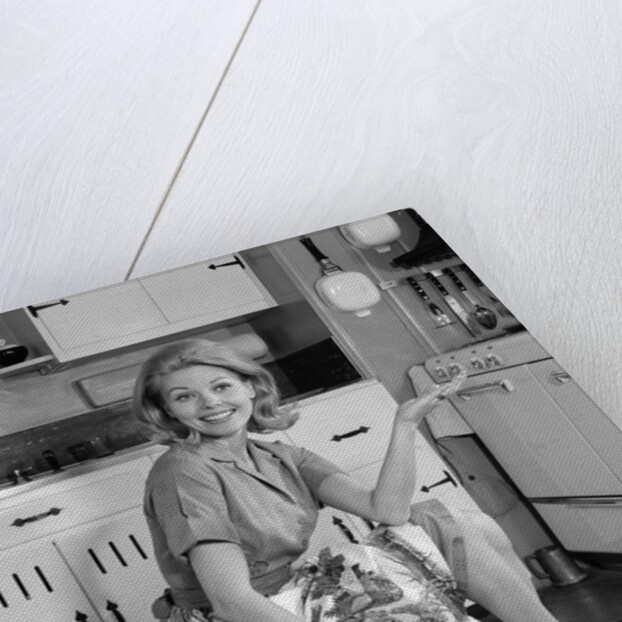 1960s smiling housewife sitting on full laundry basket by Anonymous
