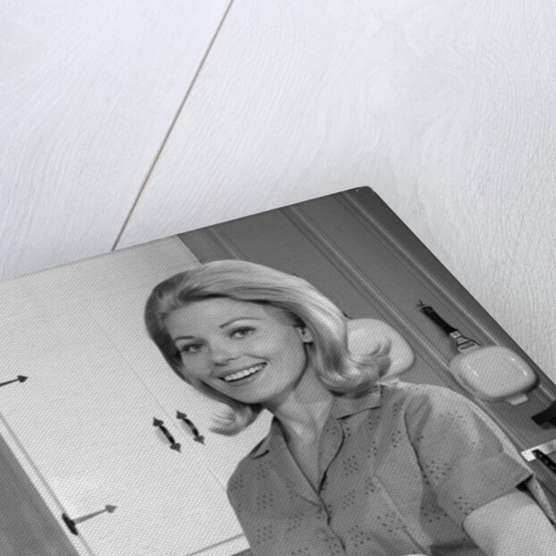 1960s 1970s smiling blond housewife in kitchen holding mixing bowl by Anonymous