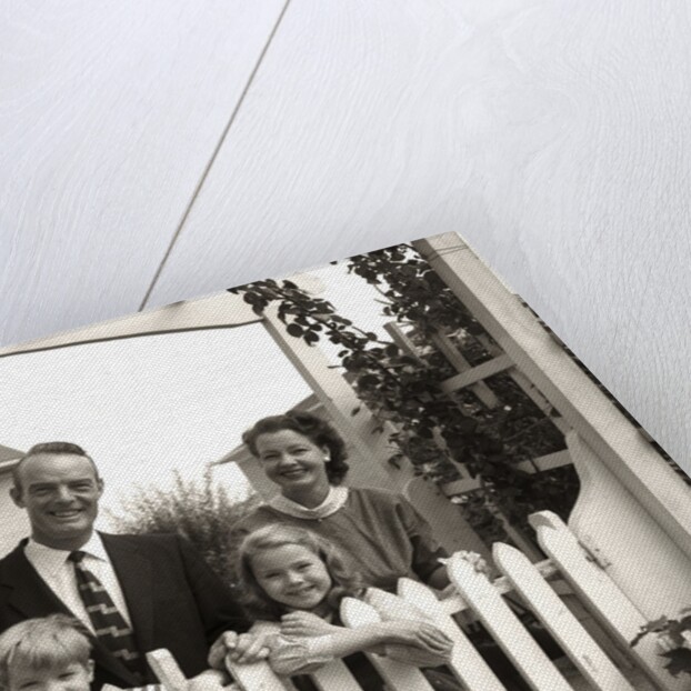 1950s family of four behind picket fence by Anonymous