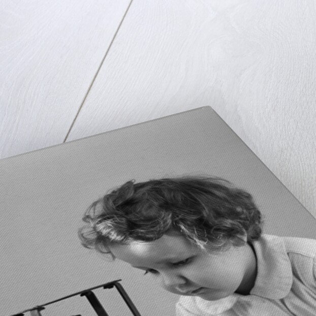 1940s young girl leaning on table staring at hourglass by Anonymous