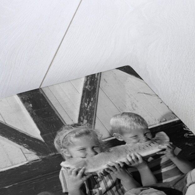 1960s boy and girl sharing a slice of watermelon by Anonymous