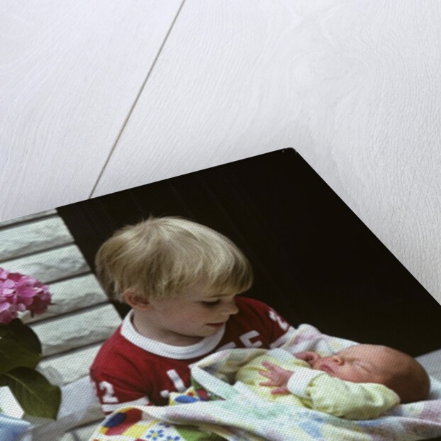 1970s boy holding a newborn baby by Anonymous