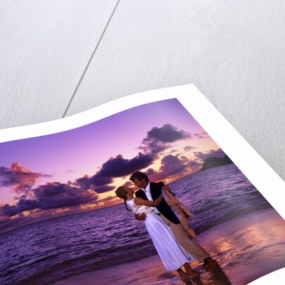 Dressed up couple embracing on the beach at sunset by Anonymous