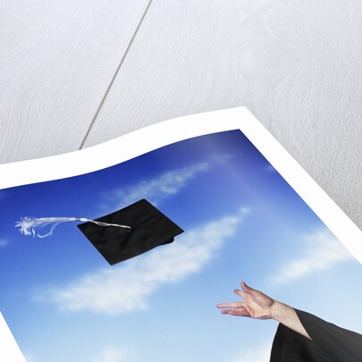 Graduate tossing mortarboard hat into the air by Anonymous