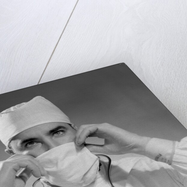 1960s male doctor wearing surgical mask and operating room scrubs by Anonymous