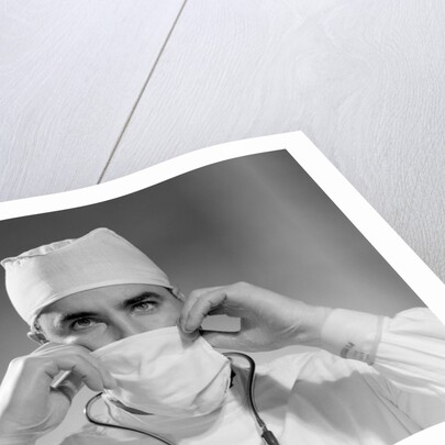 1960s male doctor wearing surgical mask and operating room scrubs by Anonymous