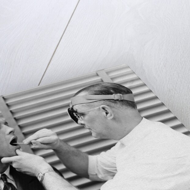 1930s 1940s doctor examining throat of a young man by Anonymous