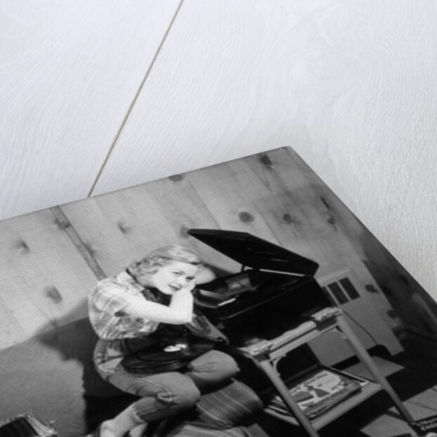 1950s teenage girl listening to music on a phonograph by Anonymous
