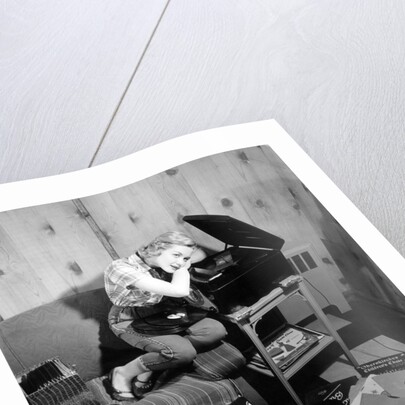 1950s teenage girl listening to music on a phonograph by Anonymous