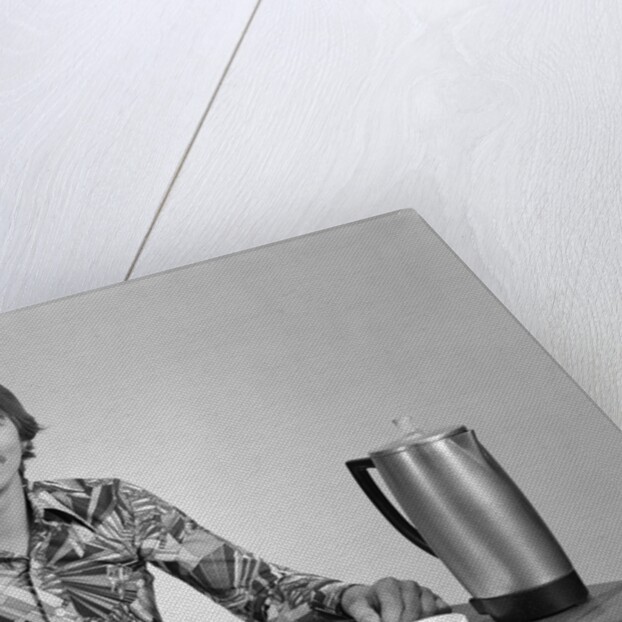 1970s smiling young man working on a budget by Anonymous