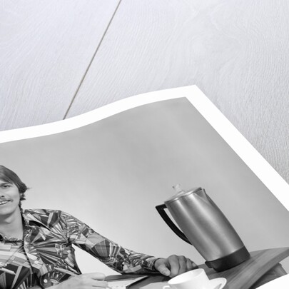 1970s smiling young man working on a budget by Anonymous