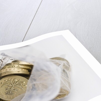 Looking down into an open money bag of pound coins by Anonymous