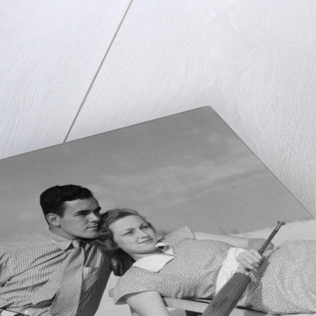 1930s couple lying on a beach by Anonymous