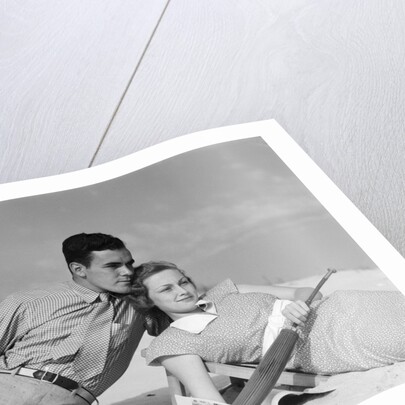 1930s couple lying on a beach by Anonymous