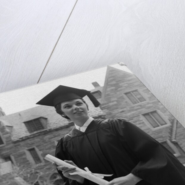 1950s smiling female graduate holding a diploma by Anonymous