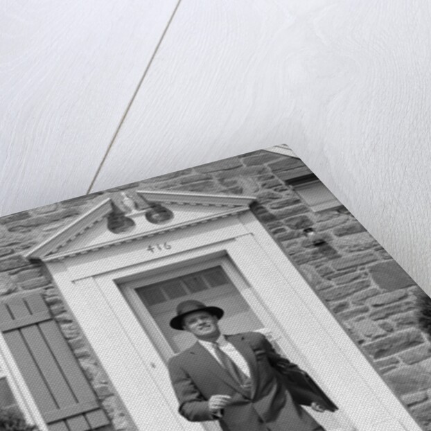 1950s smiling businessman walking out the front door of his house by Anonymous