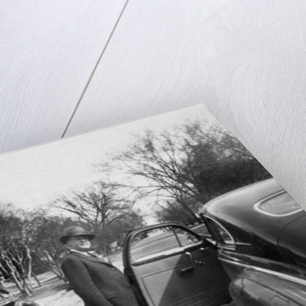 Mature man open his car door, ca. 1940. by Anonymous