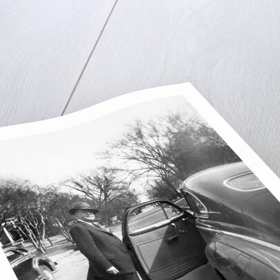 Mature man open his car door, ca. 1940. by Anonymous