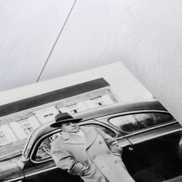 Mature man stands by his car, ca. 1942. by Anonymous