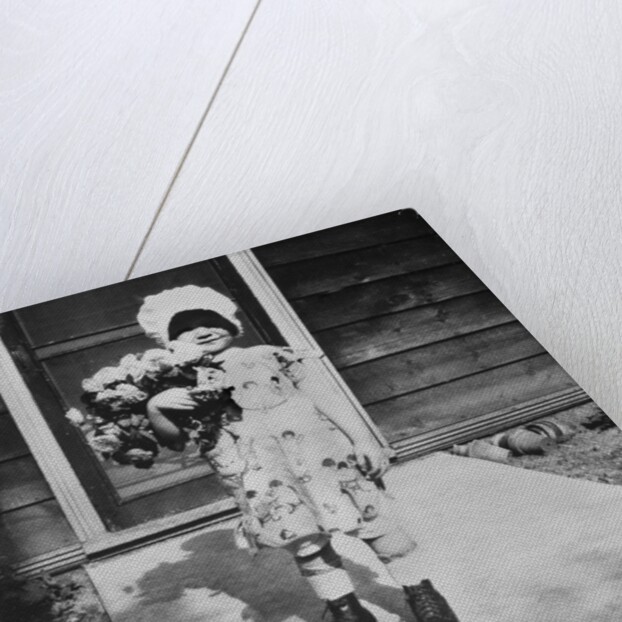 Young girl with a bouquet of flowers on her doorstep, ca. 1928. by Anonymous