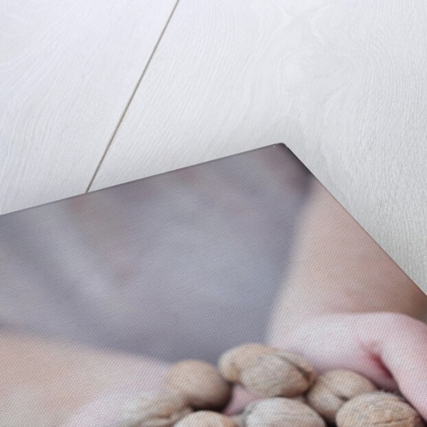 Man in khaki t-shirt holds walnuts in his palms by Anonymous