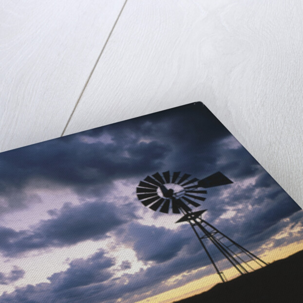 Windmill Silhouette Under Broken Clouds by Anonymous